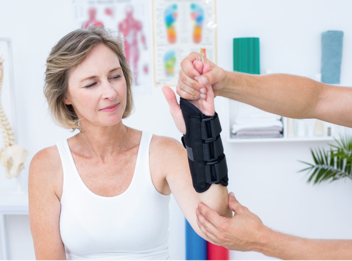 Frau mit gebrochenem Arm bei Physiotherapie