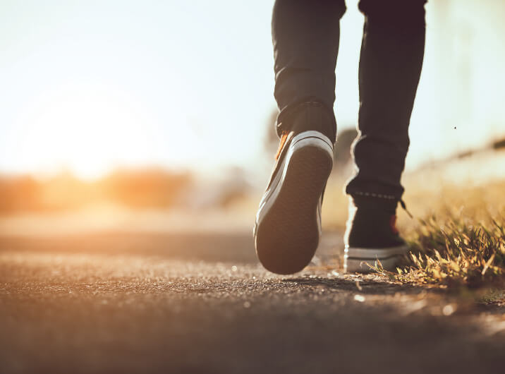 Person geht Sonnenuntergang entgegen