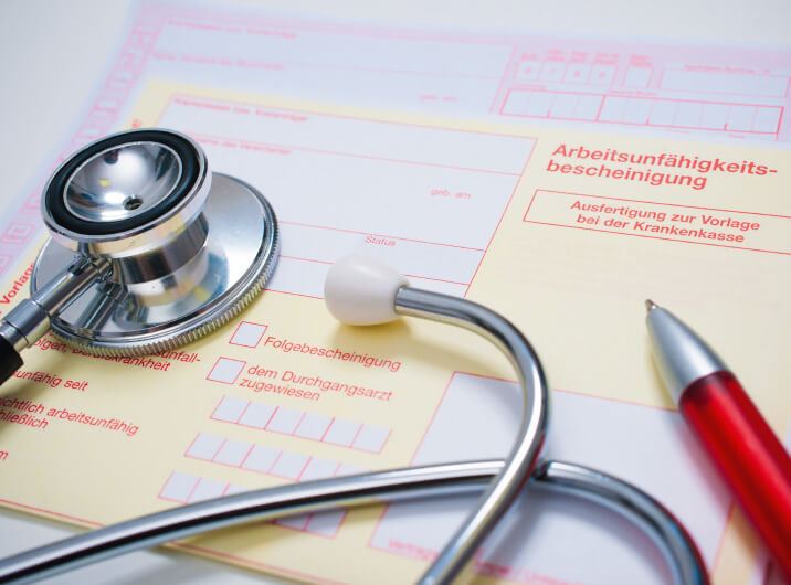 Stethoskop liegt auf Arbeitsunfähigkeitsbescheinigung